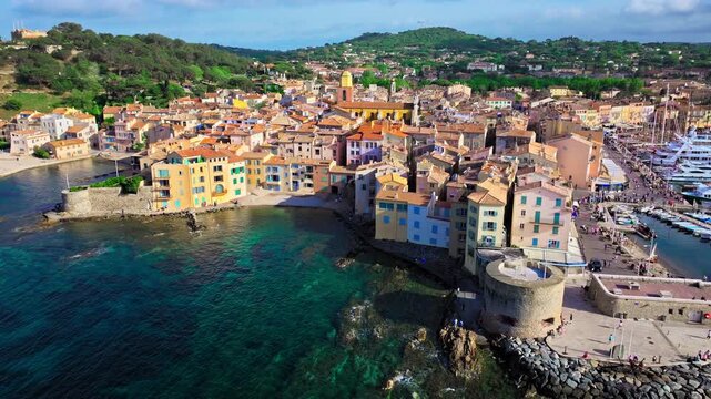 Aerial view of Saint-Tropez's colourful houses, church tower on the French Riviera. View from above of public beach and Catholic church, Cote d'Azur, a popular destination for travel in Europe.
