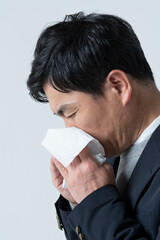 鼻をかむ50代男性