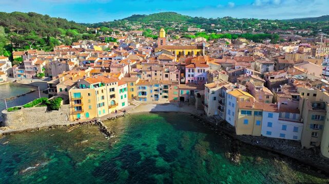 Aerial view of Saint-Tropez's colourful houses, church tower on the French Riviera. View from above of public beach and Catholic church, Cote d'Azur, a popular destination for travel in Europe.