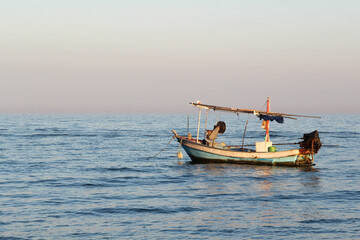 Fototapeta premium A small fishing boat floating in the sea