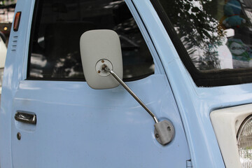 A light blue small truck park on the side of the road