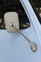 A light blue small truck park on the side of the road