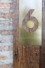 Wooden and brick wall with sign of room number in hotel resort