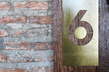 Wooden and brick wall with sign of room number in hotel resort