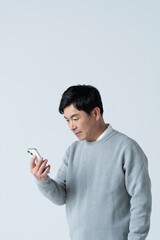 スマートフォンを見る50代男性