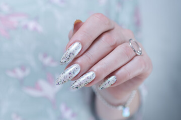 beautiful female hands with long nails light white and green manicure