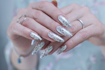 beautiful female hands with long nails light white and green manicure