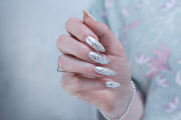 beautiful female hands with long nails light white and green manicure