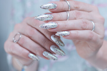 beautiful female hands with long nails light white and green manicure