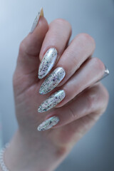 beautiful female hands with long nails light white and green manicure