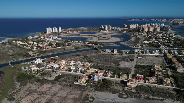 View on the canal in Mar Menor and an interesting arched bridge Puente de La Risa in the midst of a hot day.