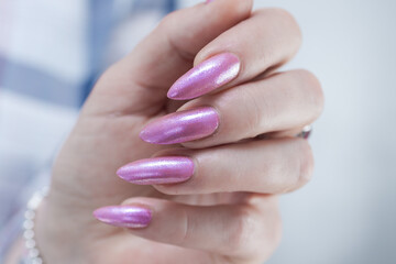 Woman's hands with long nails and light pink manicure 