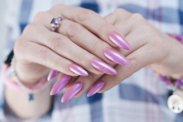 Woman's hands with long nails and light pink manicure 