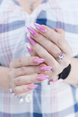 Woman hand with long nails manicure and light pink nail polish