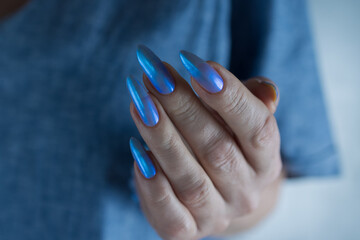 Woman's beautiful hand with long nails and light baby blue manicure	