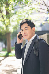 街中で電話をする50代男性