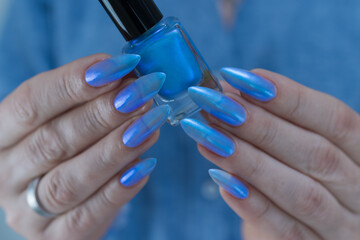 Woman's beautiful hand with long nails and light baby blue manicure