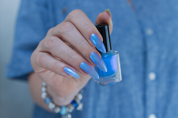 Woman's beautiful hand with long nails and light baby blue manicure