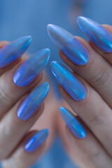 Woman's beautiful hand with long nails and light baby blue manicure