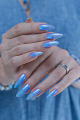 Woman's beautiful hand with long nails and light baby blue manicure