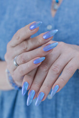 Woman's beautiful hand with long nails and light baby blue manicure