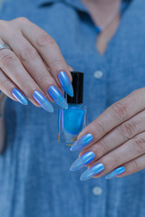 Woman's beautiful hand with long nails and light baby blue manicure