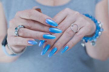 Woman's beautiful hand with long nails and light baby blue manicure	