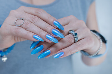 Woman's beautiful hand with long nails and light baby blue manicure	