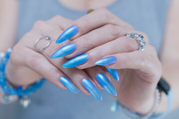 Woman's beautiful hand with long nails and light baby blue manicure	