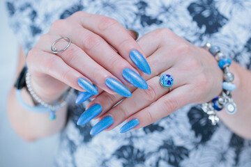 Woman's beautiful hand with long nails and light baby blue manicure	