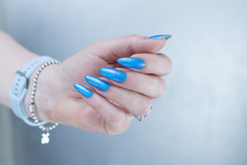 Female hand with long nails and light blue manicure