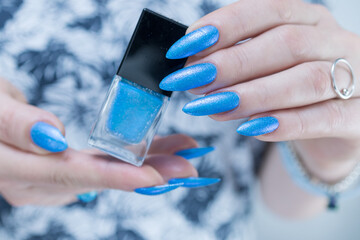 Female hand with long nails and light blue manicure