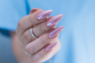 Woman's hands with long nails and a light pink color nail polish