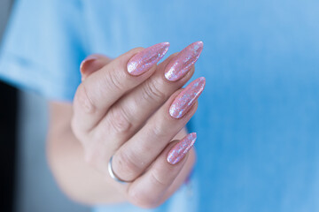 Woman's hands with long nails and a light pink color nail polish