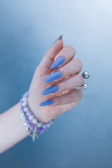 Woman's beautiful hand with long nails and matt light blue manicure	