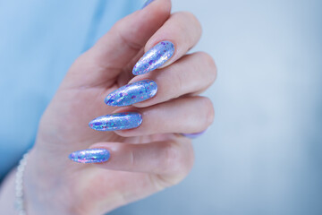 Woman's beautiful hand with long nails and bright blue manicure