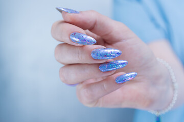 Woman's beautiful hand with long nails and bright blue manicure
