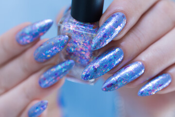 Woman's beautiful hand with long nails and bright blue manicure