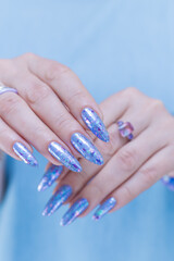 Fototapeta premium Woman's beautiful hand with long nails and bright blue manicure