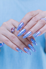 Woman's beautiful hand with long nails and bright blue manicure