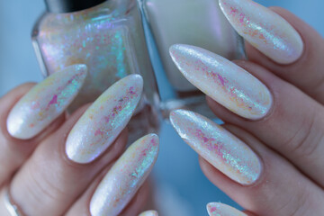 Woman's hands with long nails and a light white color nail polish