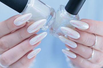 Woman's hands with long nails and a light white color nail polish