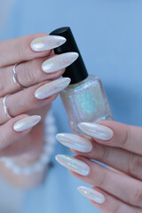 Woman's hands with long nails and a light white color nail polish