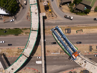 From above, witness the vibrant hustle of a modern tropical Asian traffic junction, where roads...