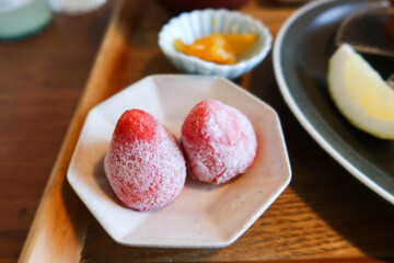 close up of two pieces of Japanese frozen iced strawberry as dessert on a white plate