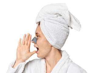 Young Caucasian redhead with pore strip shouting and holding palm near opened mouth.