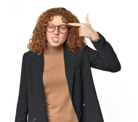 Young Caucasian redhead in business attire showing a disappointment gesture with forefinger.