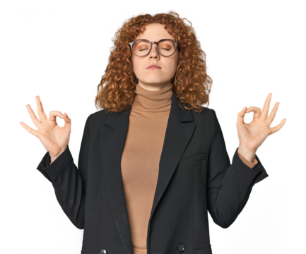 Young Caucasian redhead in business attire relaxes after hard working day, she is performing yoga.