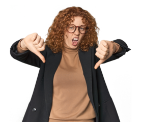 Young Caucasian redhead in business attire showing thumb down and expressing dislike.