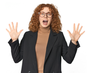 Young Caucasian redhead in business attire receiving a pleasant surprise, excited and raising hands.